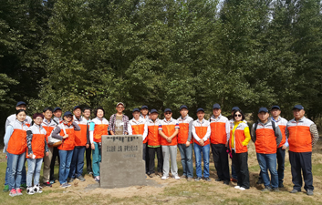 伟德官网在线服务平台绿化队和NGO组织大泷先生在已经培育成功的绿化林地前合影留念